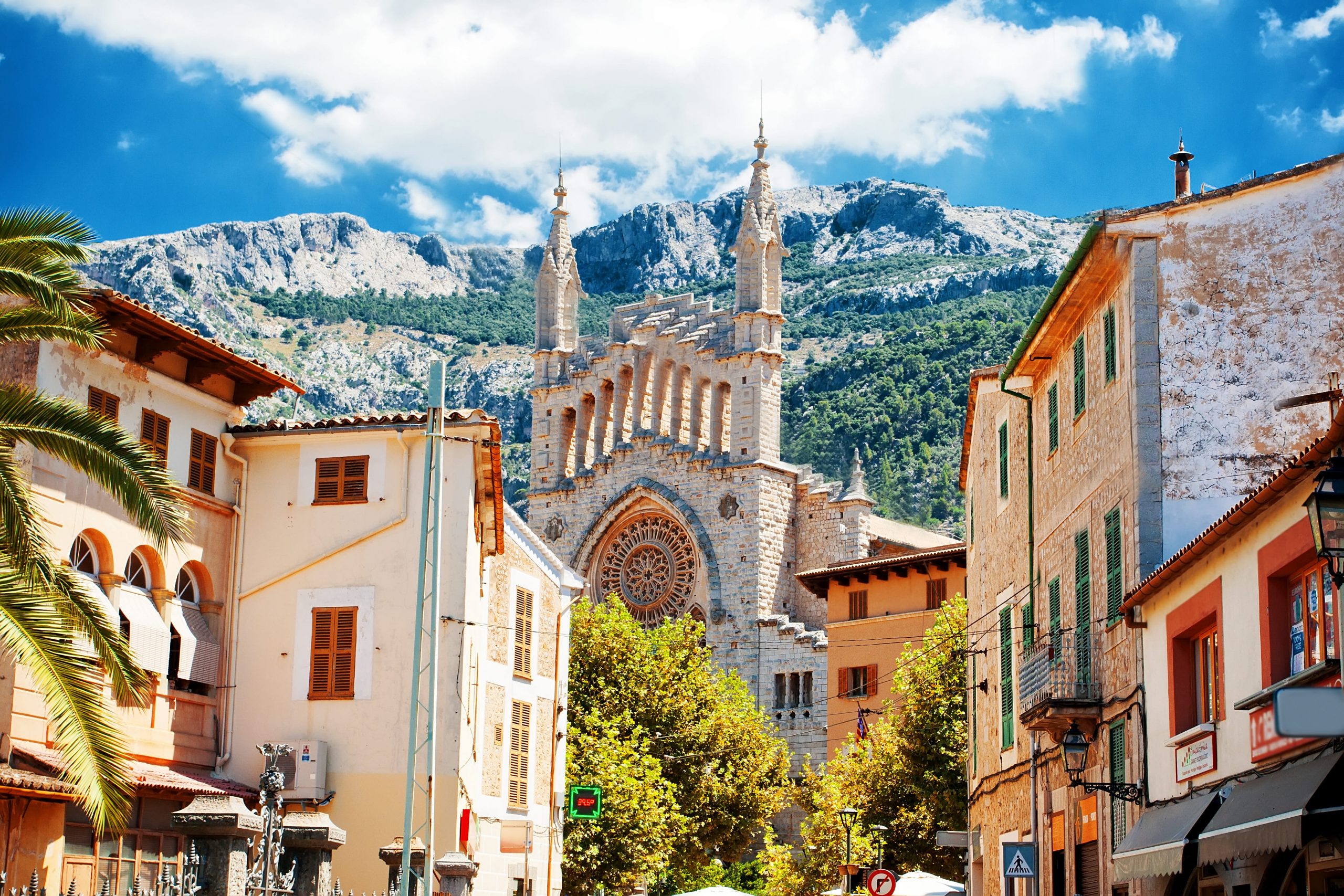 Dorf auf Mallorca und hinter einer Kirchen lassen sich Bergspitzen erkennen